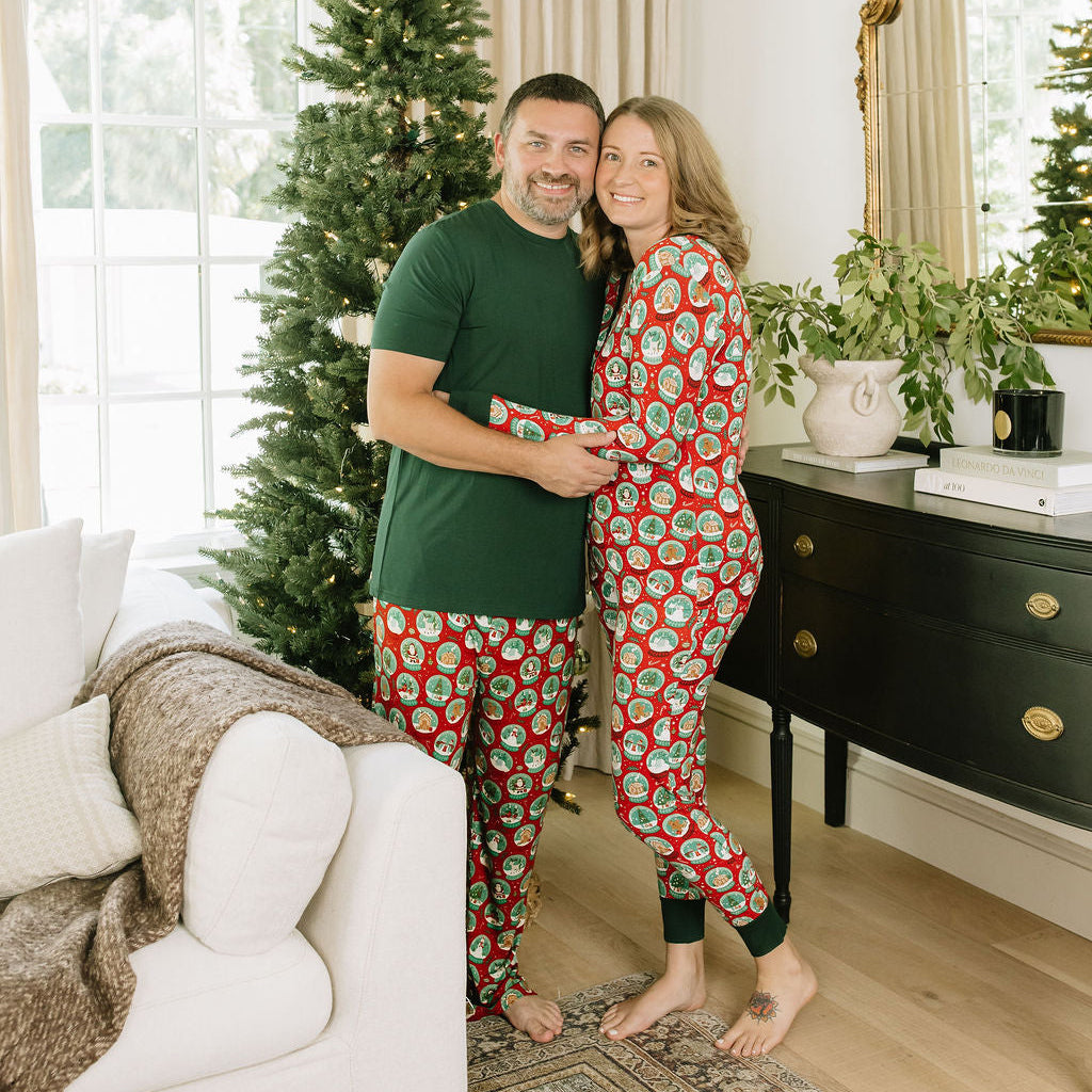 Family of five wearing coordinating Let It Snow Christmas bamboo pajamas while sitting together on a white couch.