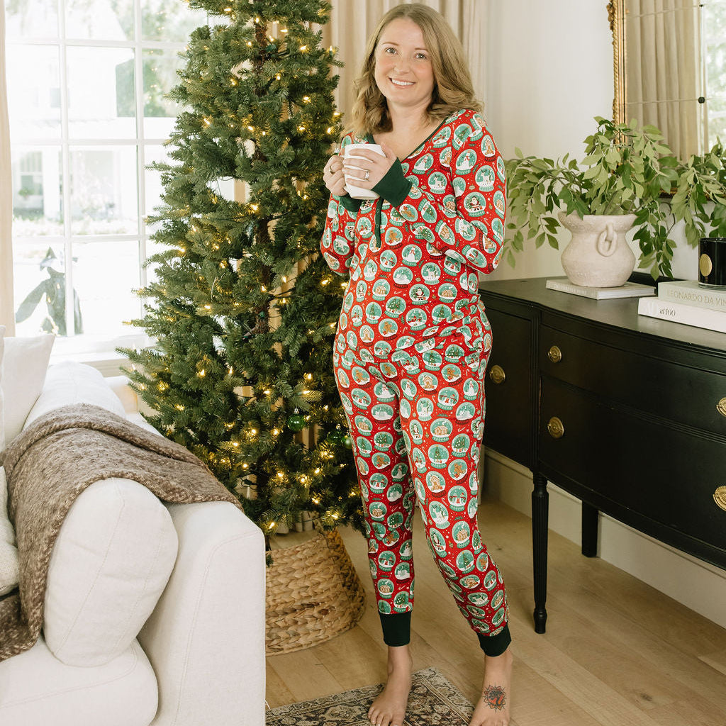 Full-length view of woman modeling Let It Snow Bamboo Pajama Jogger Pants and matching Christmas pajamas indoors.