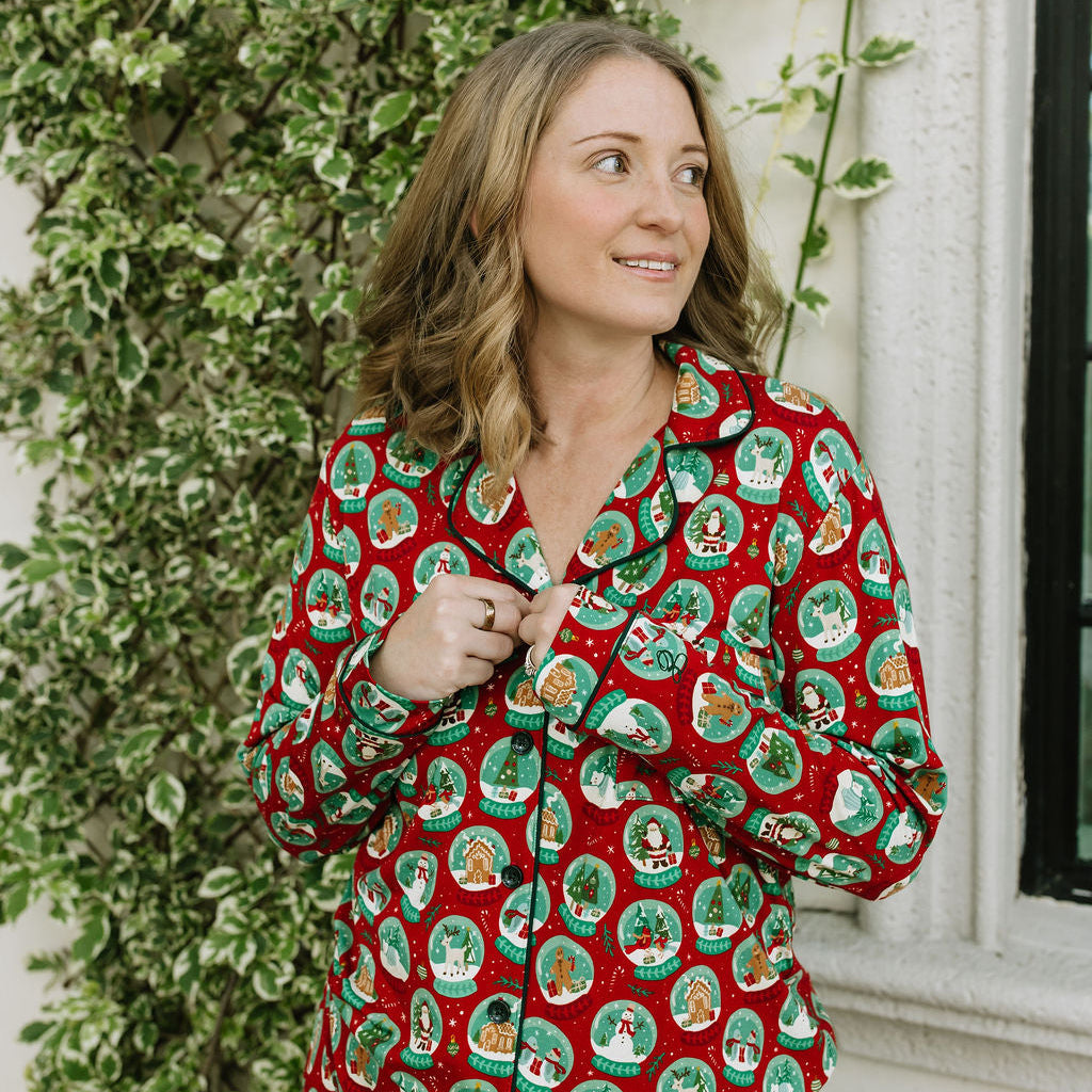 Woman wearing Let It Snow Bamboo Long Sleeve Pajama Set with red and green holiday print while standing outdoors.