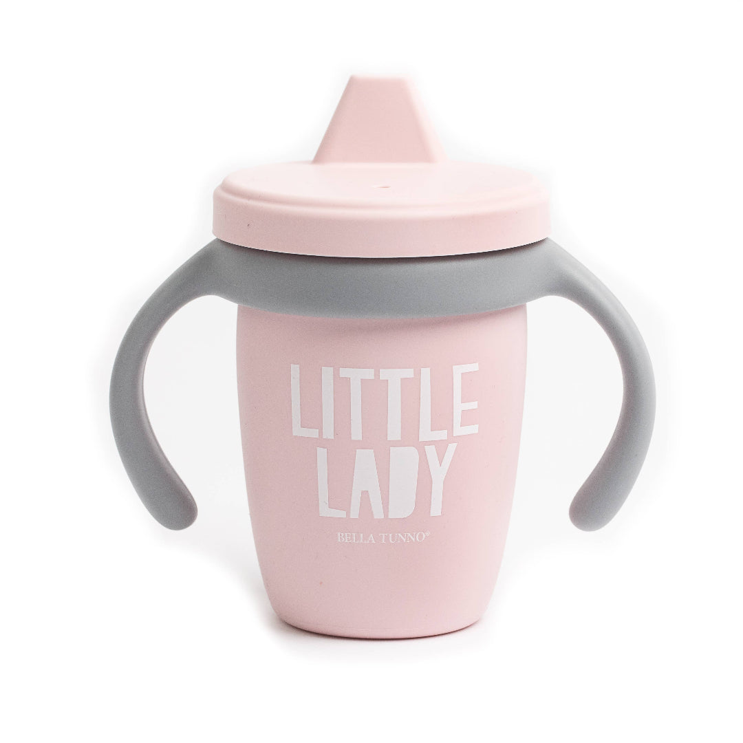 light pink sippy cup with a gray handle and it says little lady in white letters on the front