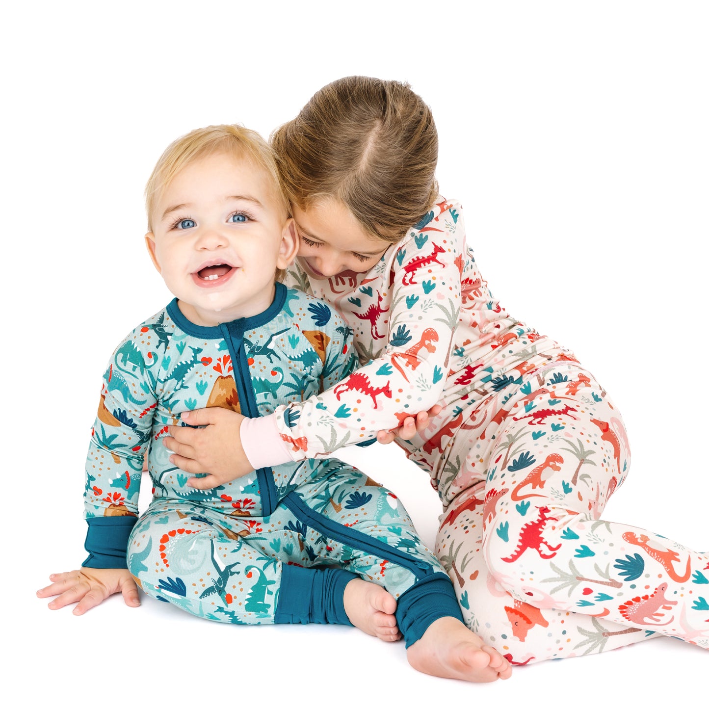Sibling matching bamboo pajamas in Lovasaurus Pink and Blue for Valentine’s Day dinosaur print