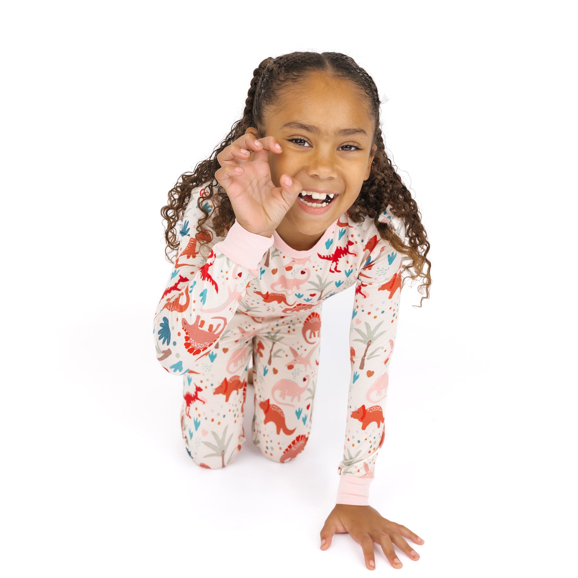 Kid playing in Lovasaurus Pink bamboo two-piece dinosaur pajama set