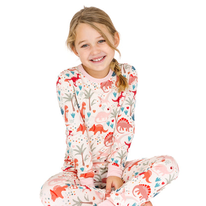 Kid sitting in Lovasaurus Pink bamboo long sleeve pajama set.