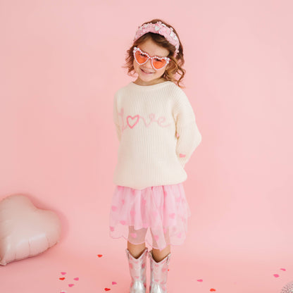 Close-up of pink Love embroidery on kids knit sweater