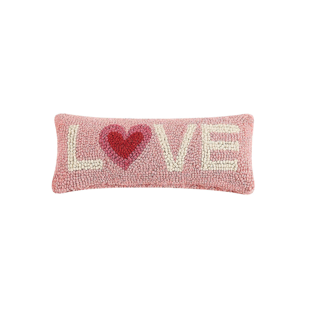 light pink hook pillow with the word love on it with white letters and a red heart in the place of the o