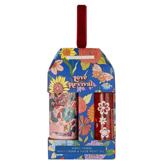Multi-colored hand cream and red bottle of pulse point oil in a blue packaged with multi-colored flowers and a butterfly