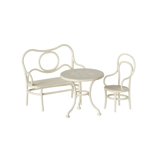White metal outdoor furniture set with bench, chair, and table on a white background