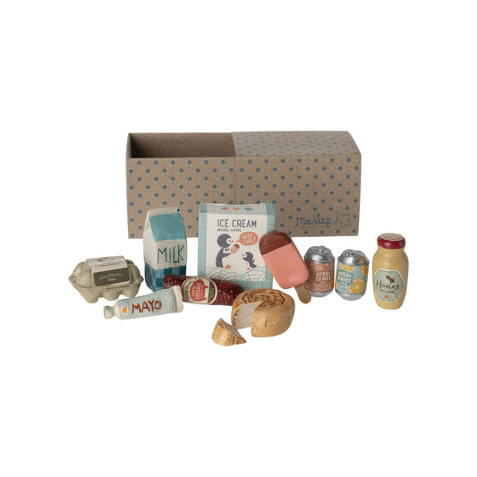 Miniature food items and packaging arranged in front of a cardboard box with a polka dot pattern.