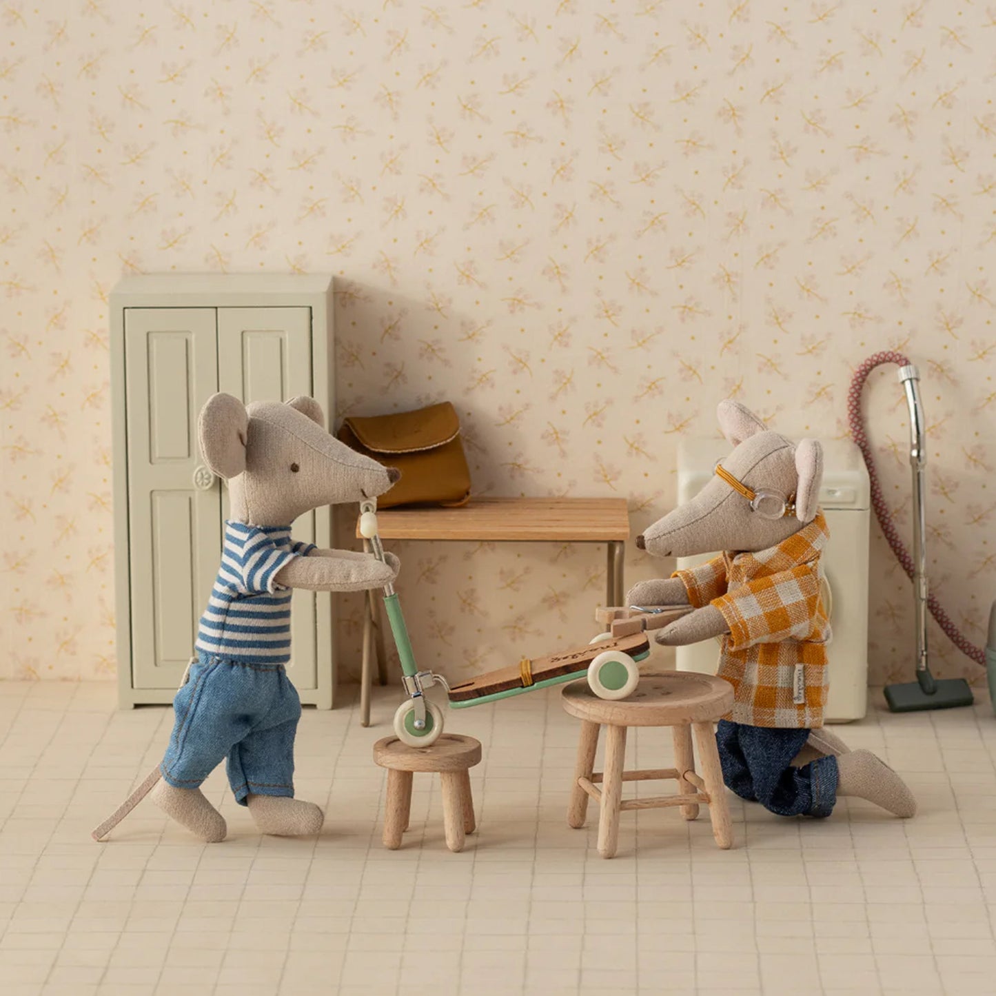 Two toy mice in a room setting with furniture and decor.