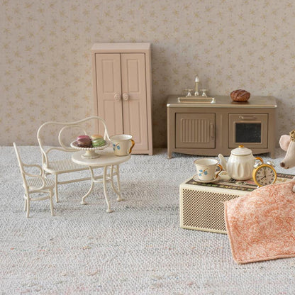 Miniature dollhouse living room with furniture and decor.