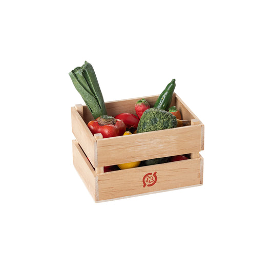 Wooden crate filled with various vegetables on a white background