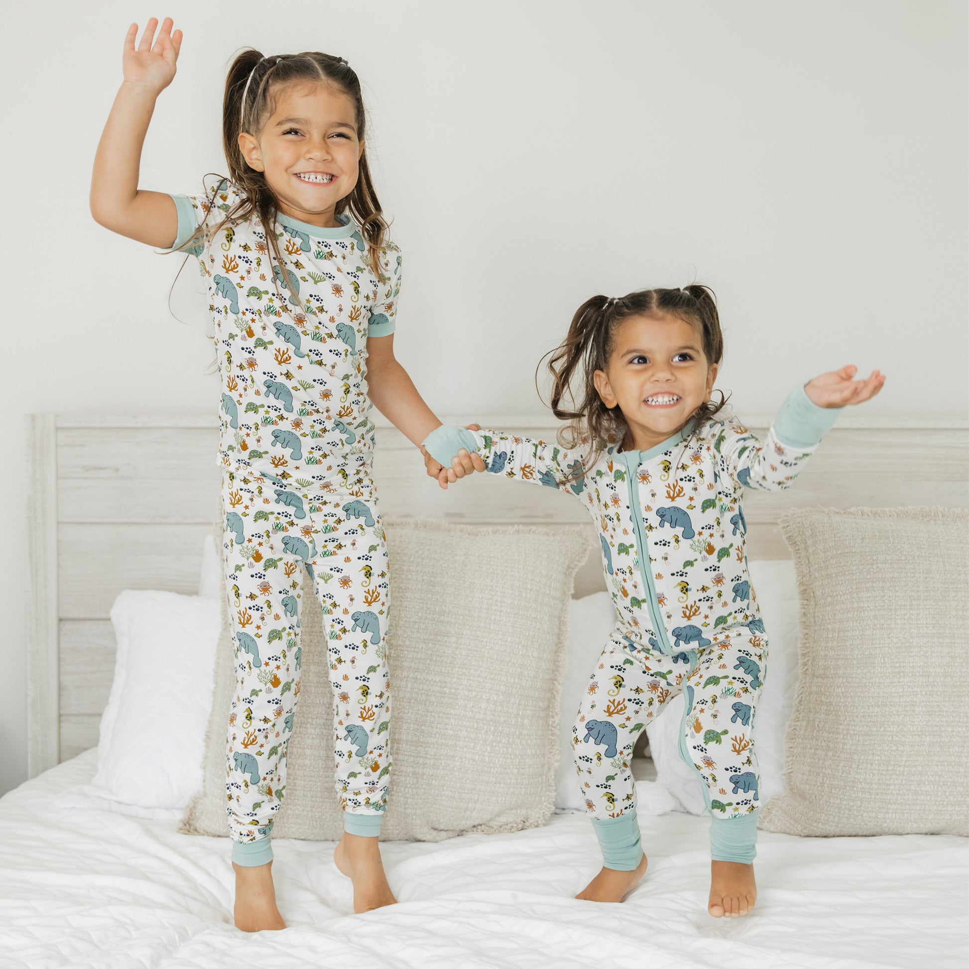 Kids wearing matching manatee bamboo pajamas standing and smiling in soft breathable sleepwear