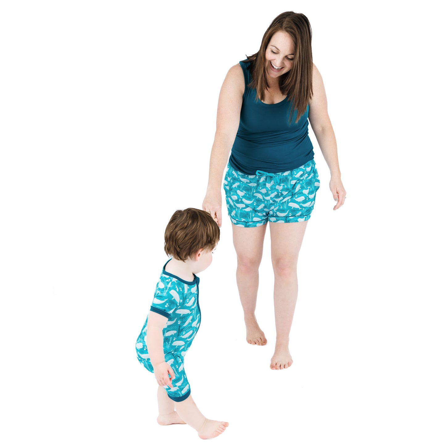 Woman and child wearing matching blue pajama sets with white patterns on a white background