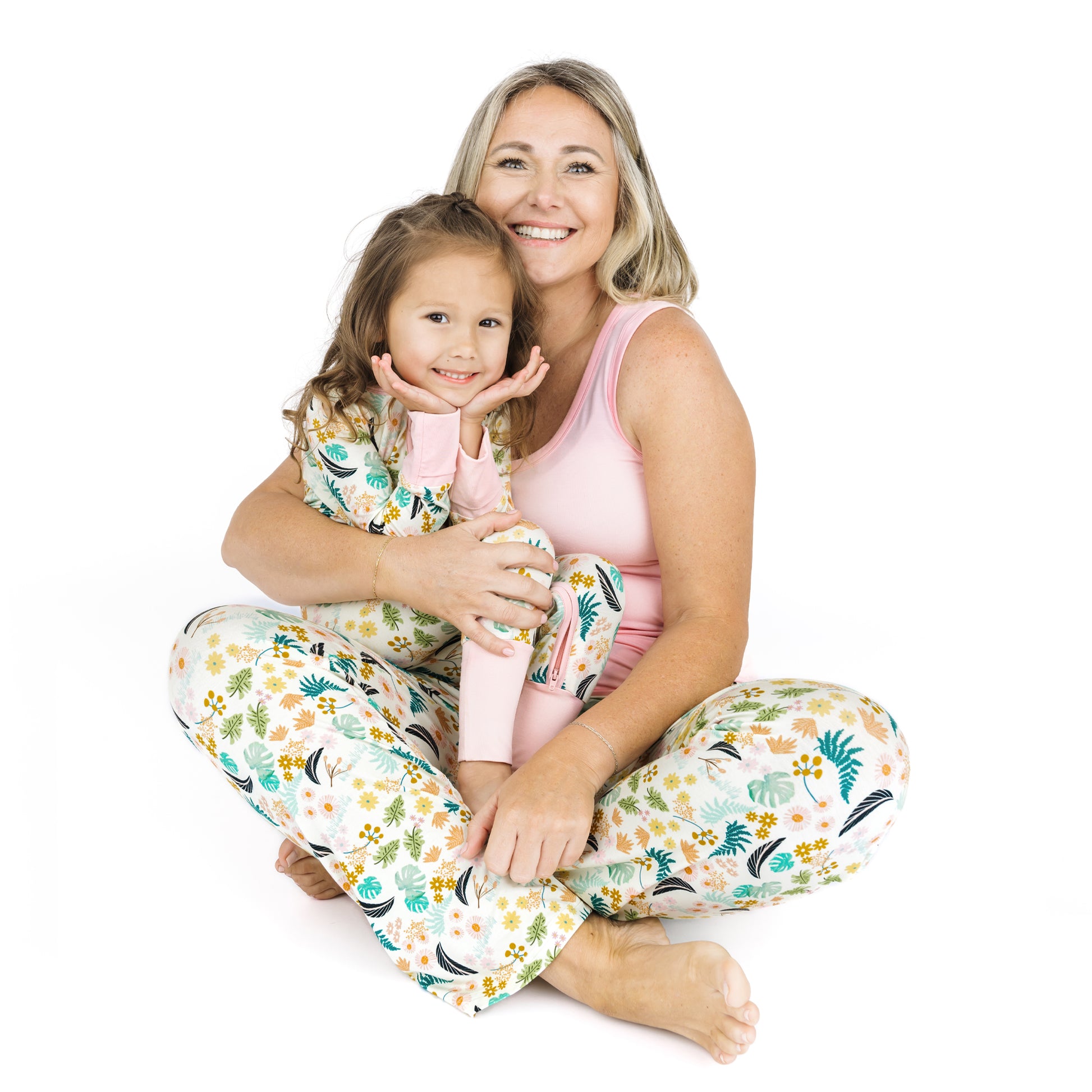 A mother and child sitting together wearing matching Tropical Blooms print pajamas for coordinated family lounging.