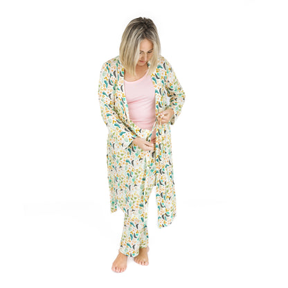 A mother wearing the Tropical Blooms luxury robe while coordinating with her children in matching botanical print styles.