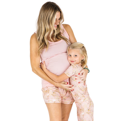 Woman and young girl in matching pink outfits on a white background