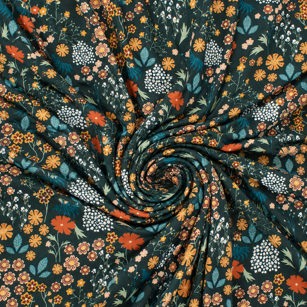 A close-up of patterned fabric arranged in a spiral drape, featuring a dark teal background with a dense floral print in orange, mustard yellow, white, and blue-green tones.