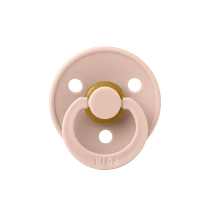 Pink pacifier with gold center on a white background