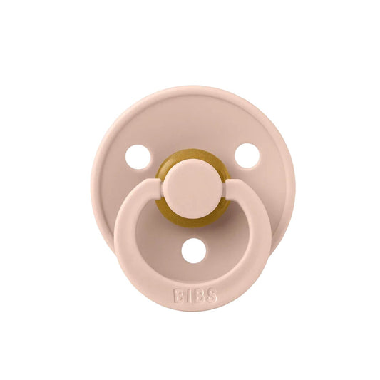 Pink pacifier with gold center on a white background