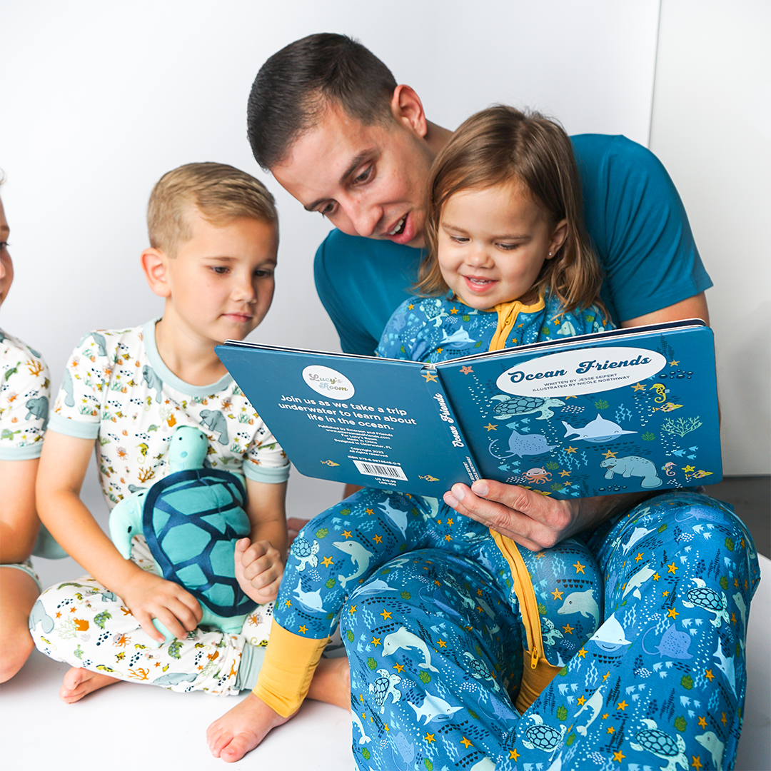 father reads the "ocean friends" board book to 2 children. 
