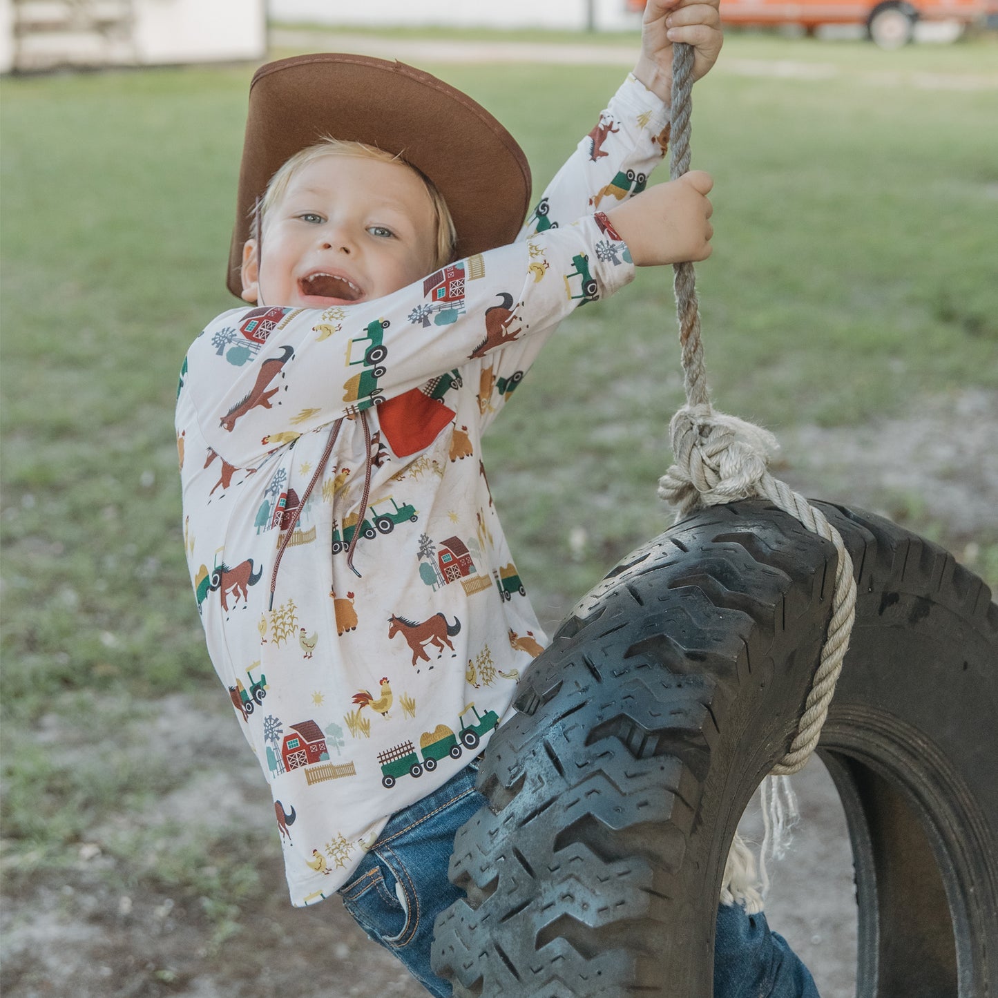 Child in On the Farm bamboo long sleeve pocket tee with farm animal print, soft and breathable hypoallergenic fabric for sensitive skin