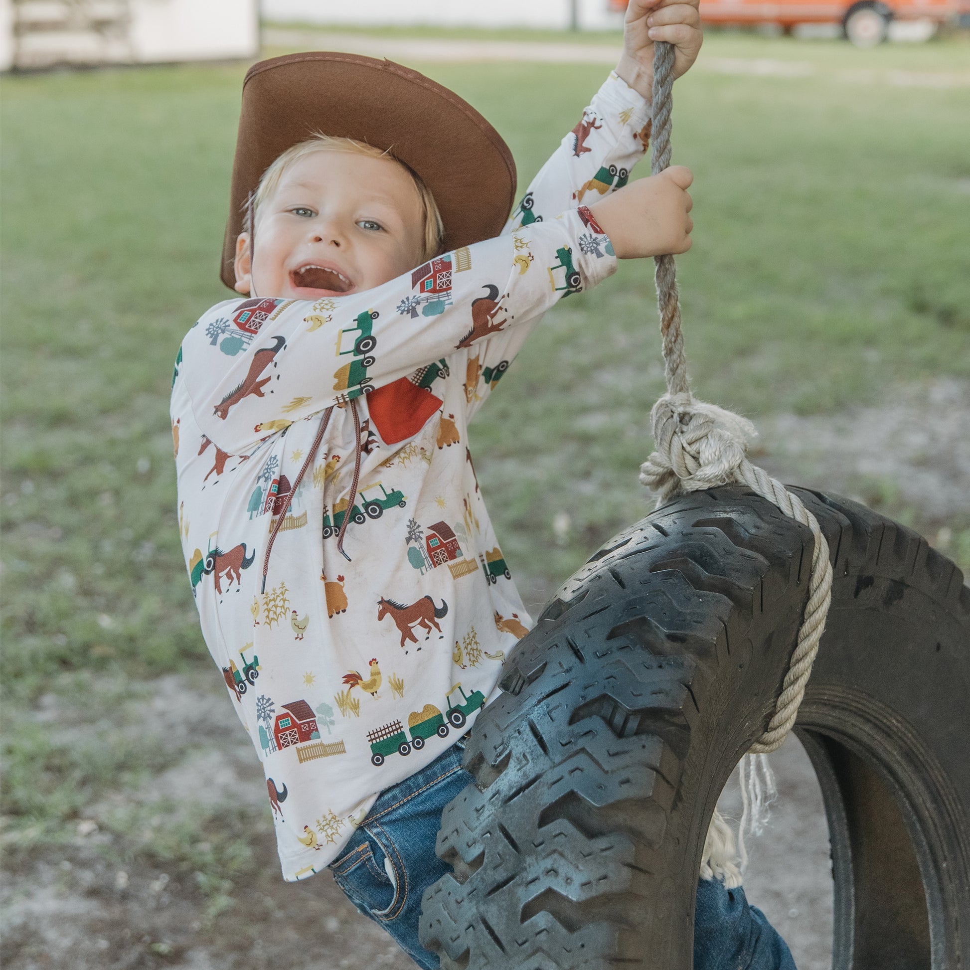 Child in On the Farm bamboo long sleeve pocket tee with farm animal print, soft and breathable hypoallergenic fabric for sensitive skin