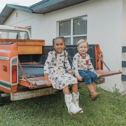 Two siblings in matching On the Farm  animal print, soft, breathable, and hypoallergenic for sensitive skin.