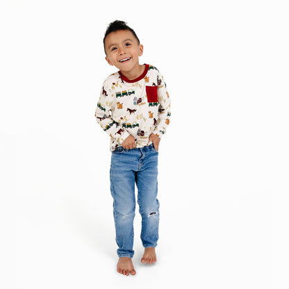 Boy wearing On the Farm bamboo long sleeve pocket tee with farm animal print, soft and breathable fabric safe for sensitive skin.