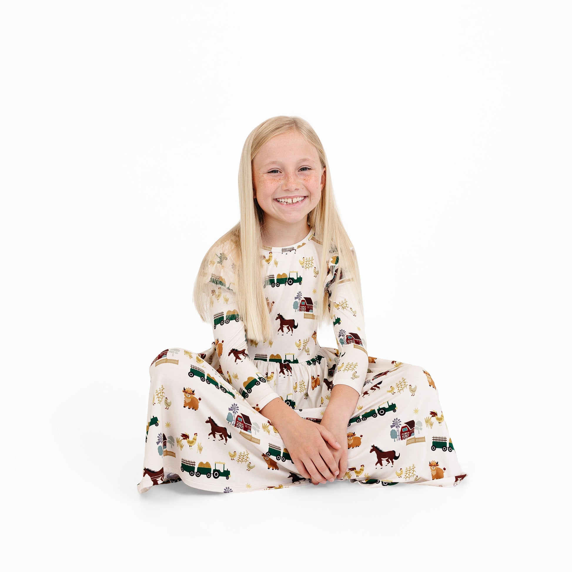 Child wearing On the Farm bamboo twirl dress with barnyard print, soft, breathable, and hypoallergenic for sensitive skin.