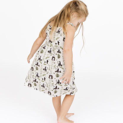Young girl wearing a dress with panda pattern on a white background