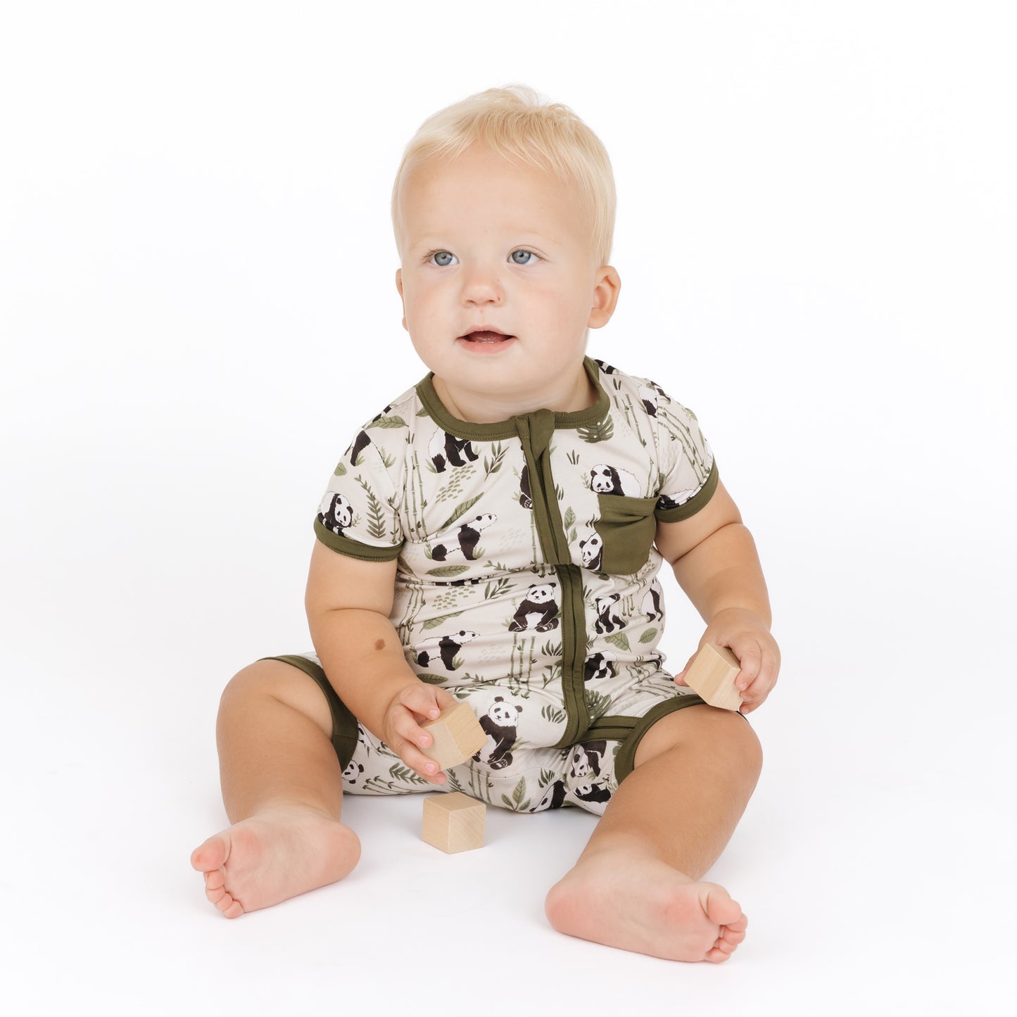 Baby wearing a romper with animal print on a white background