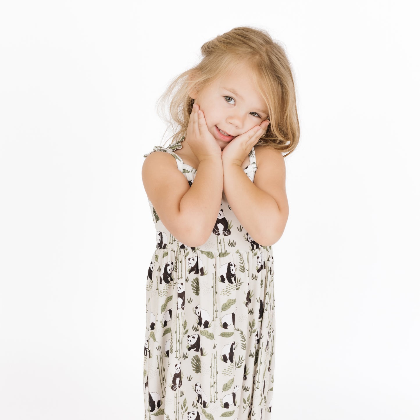 Young girl wearing a patterned dress on a white background