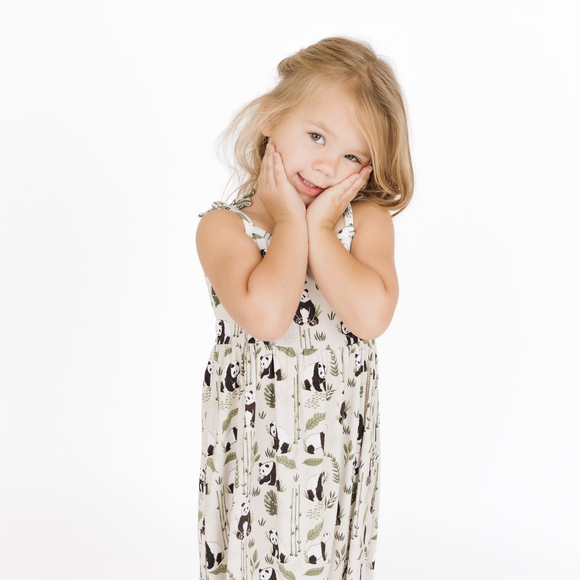 Young girl wearing a patterned dress on a white background