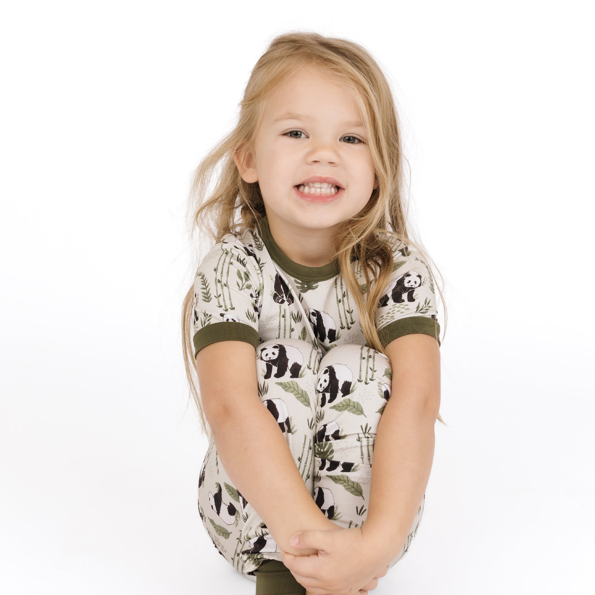 Child wearing a shirt with panda design on a white background