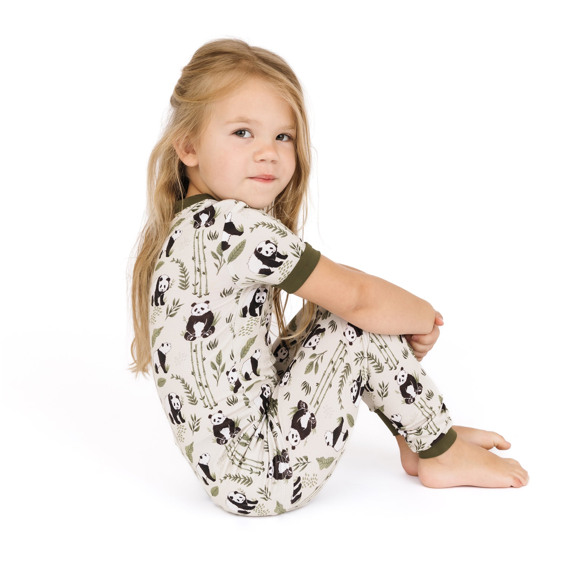 Child wearing a panda-themed onesie on a white background
