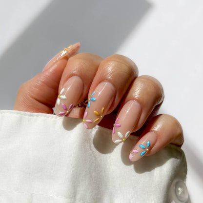 Hand with pastel nail art on a white background