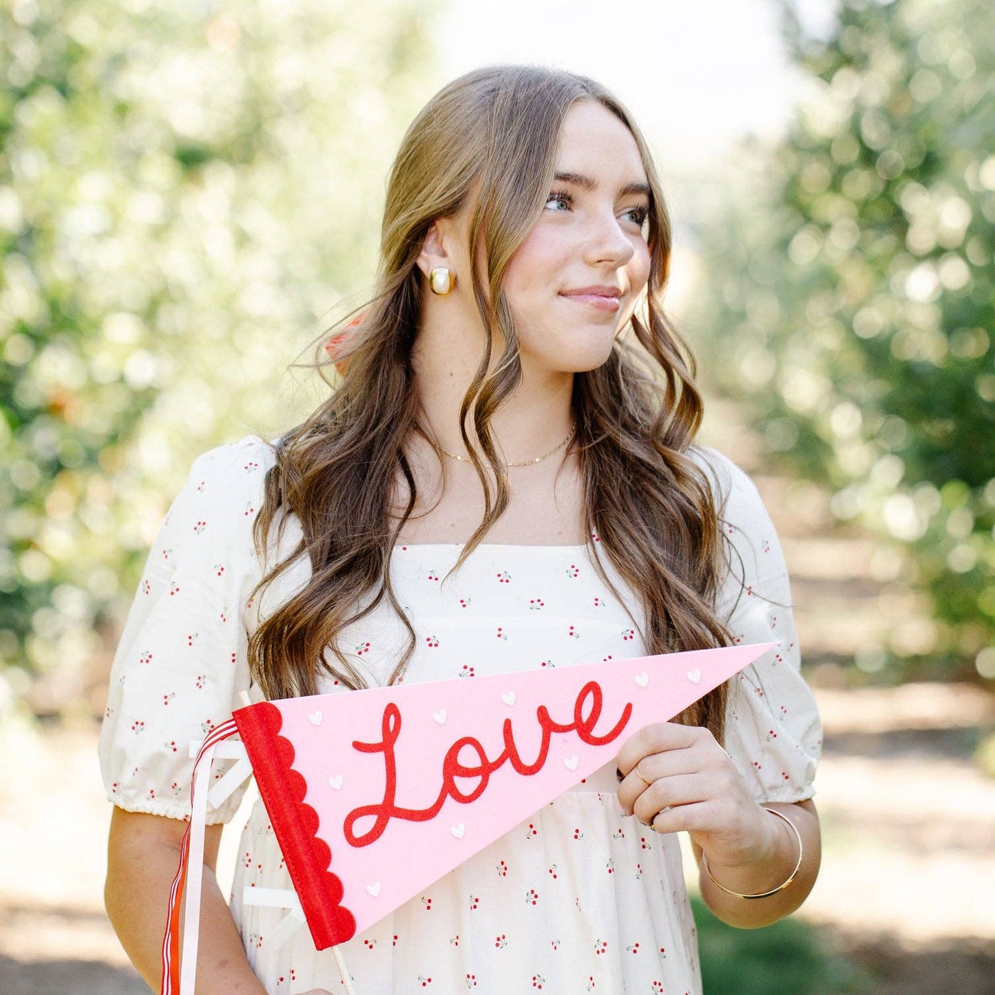 Woman holding a 'Love' sign outdoors