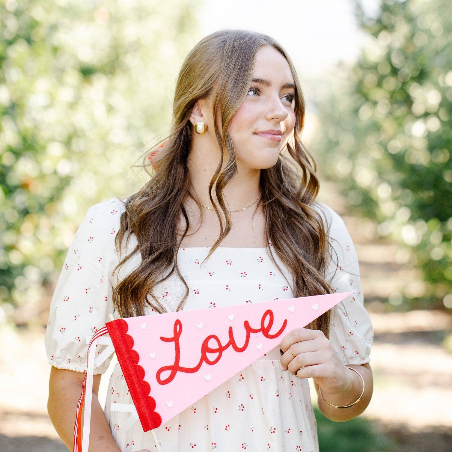 Woman holding a 'Love' sign outdoors