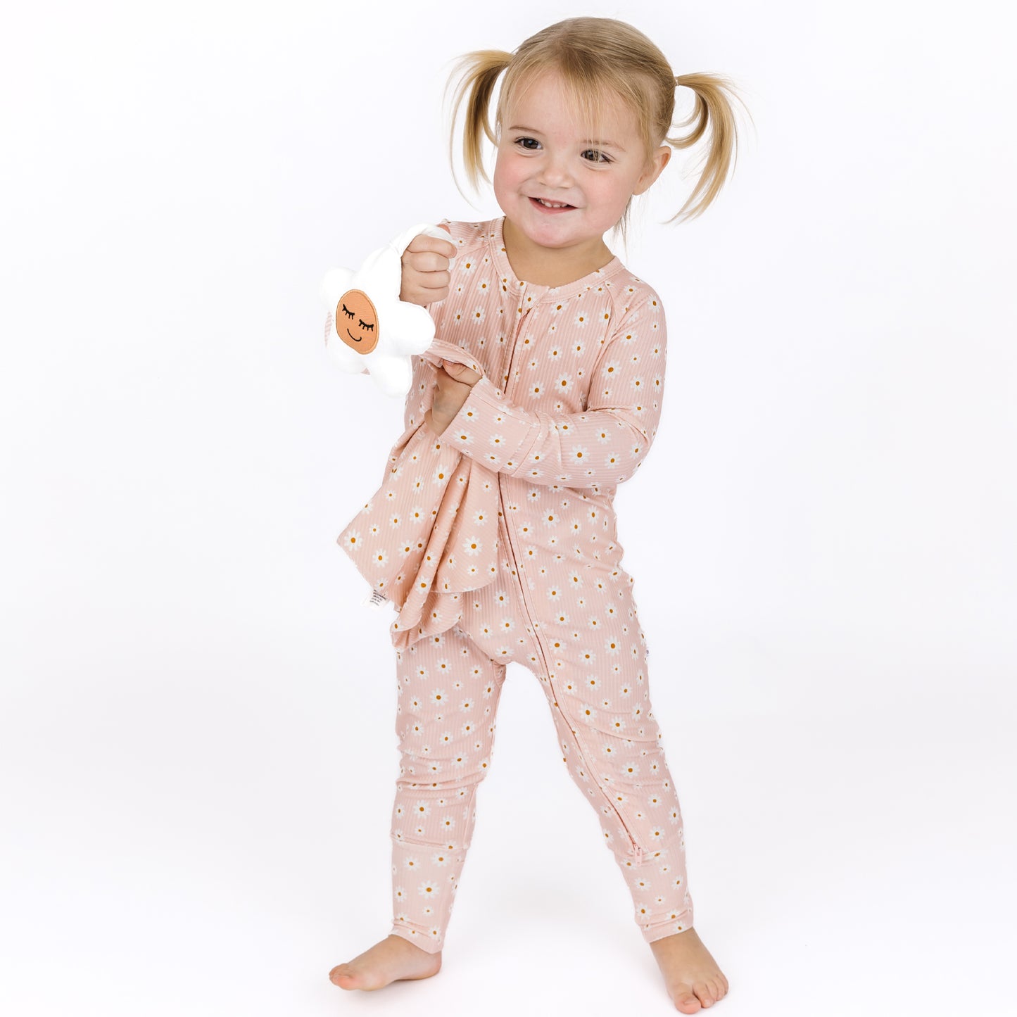 Child wearing a pink floral pajama set on a white background