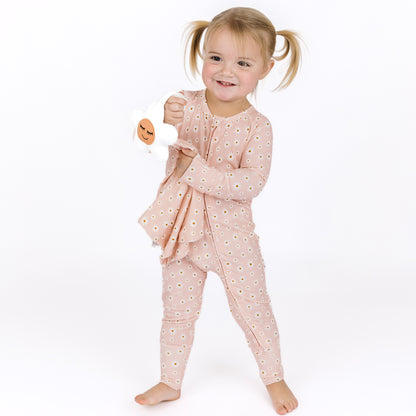 Child wearing a pink floral pajama set on a white background