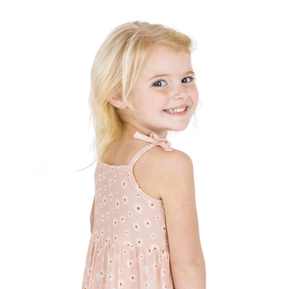 Young girl wearing a pink dress with a white background