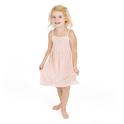 Young girl wearing a pink dress with white polka dots on a white background
