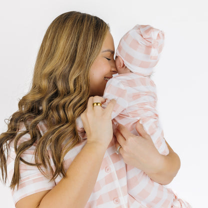Mom holding a newborn baby in a Pink Gingham bamboo gown, highlighting the soft and cozy fabric.