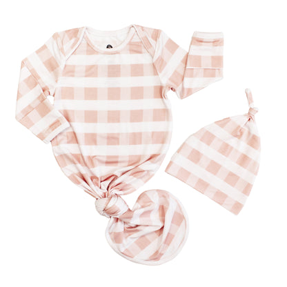Newborn baby gift set featuring a pink and white gingham checkered bamboo tie gown and matching knotted hat.