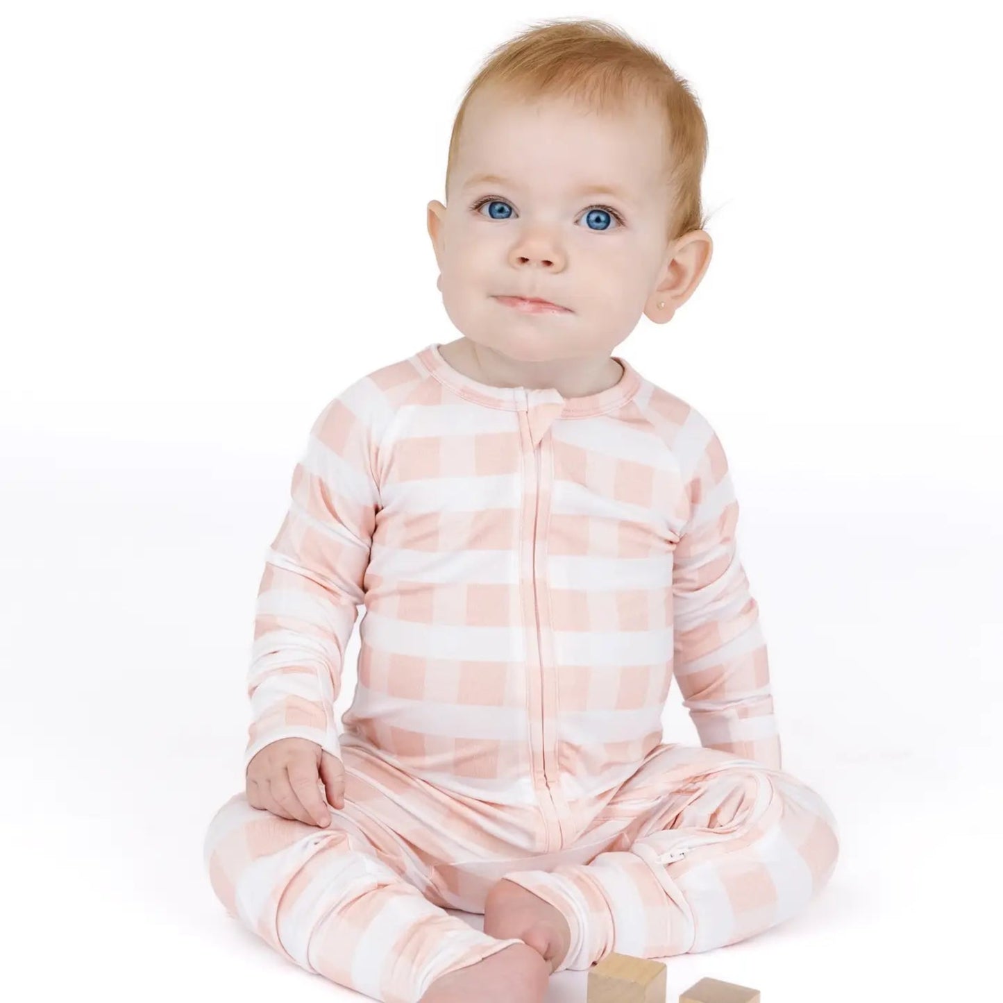 Baby wearing a pink and white striped onesie on a white background