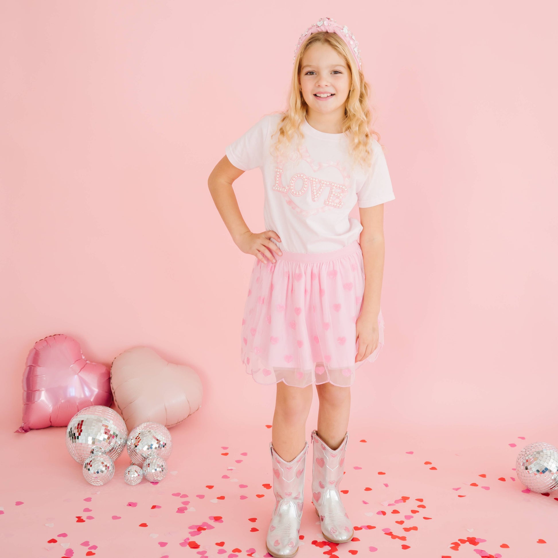 Child wearing pink heart sequin tutu skirt for Valentine’s Day.