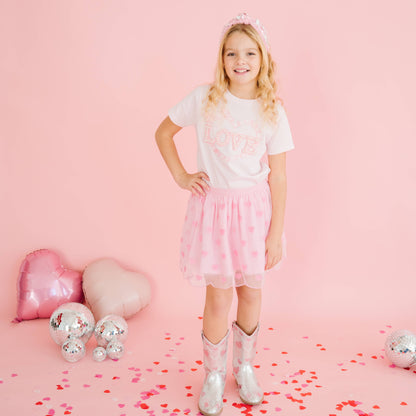 Child wearing pink heart sequin tutu skirt for Valentine’s Day.