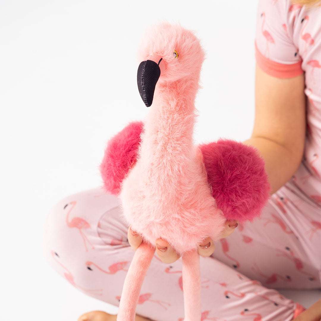 girl holds up Florence the Flamingo.