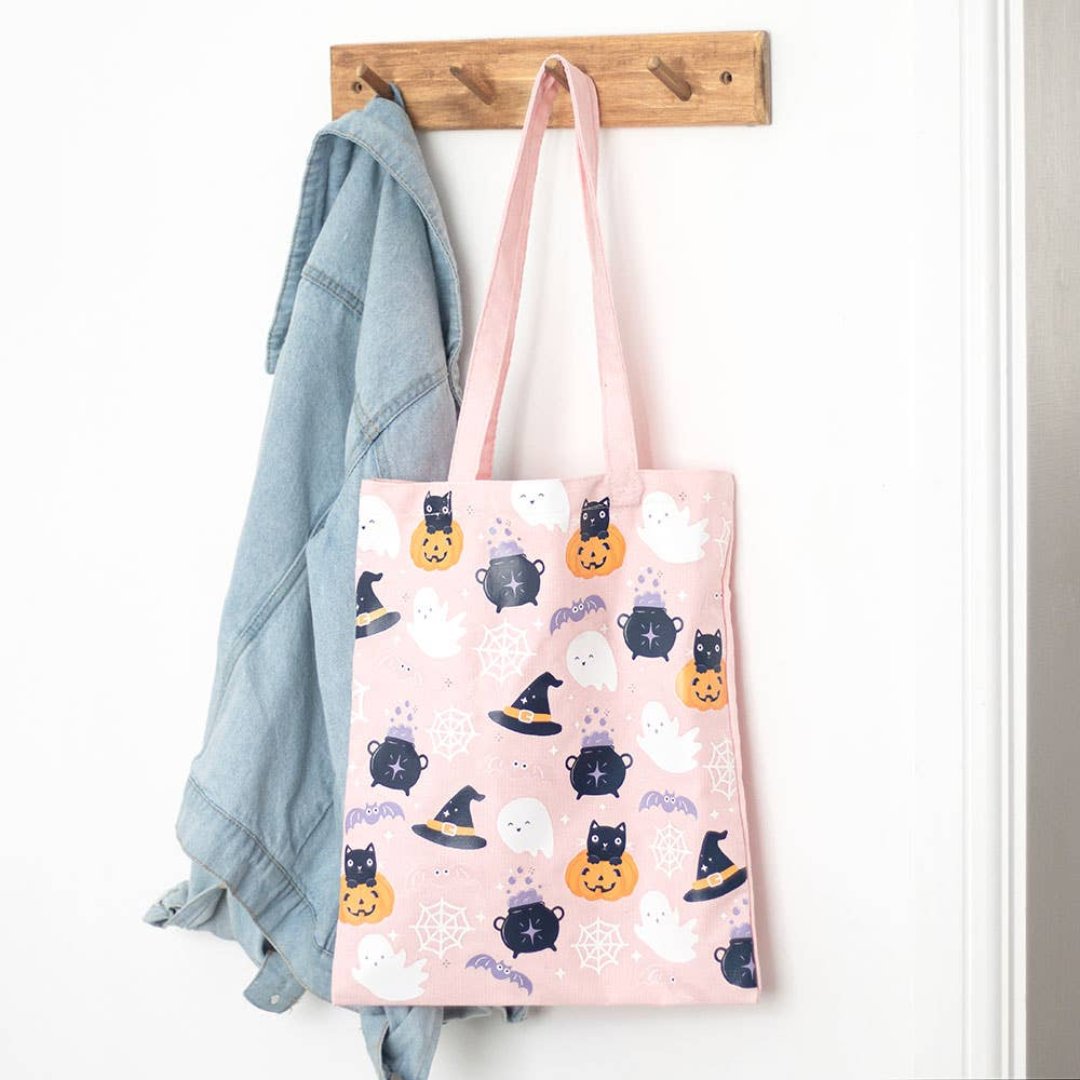 pink halloween tote hanging on a hook next to a sweater