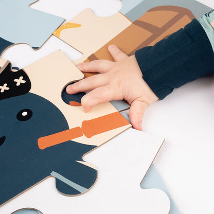 a small baby hand puts together the "pirate's life" puzzle. 